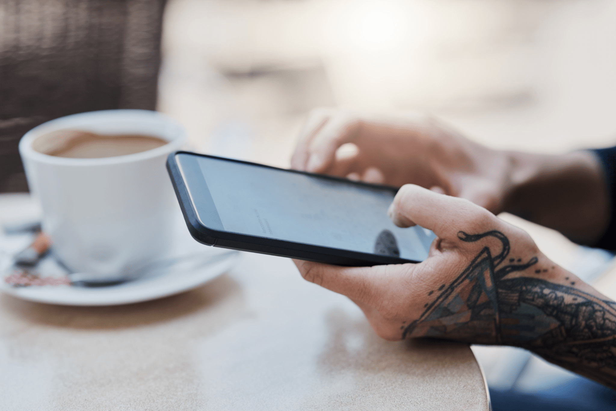 person receiving a text message at a coffee shop