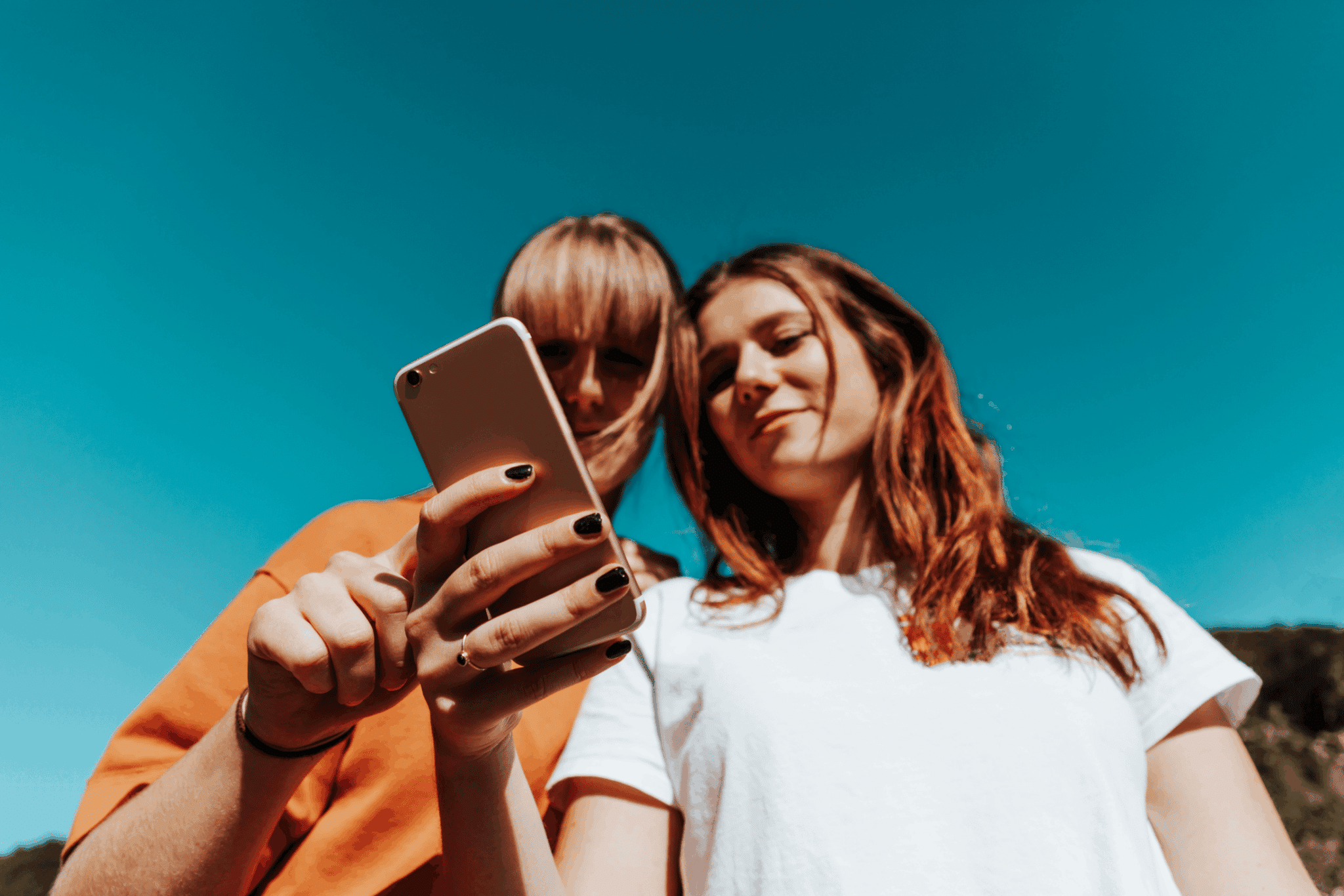 friends showing each other social media content on their phones friends showing each other social media content on their phones