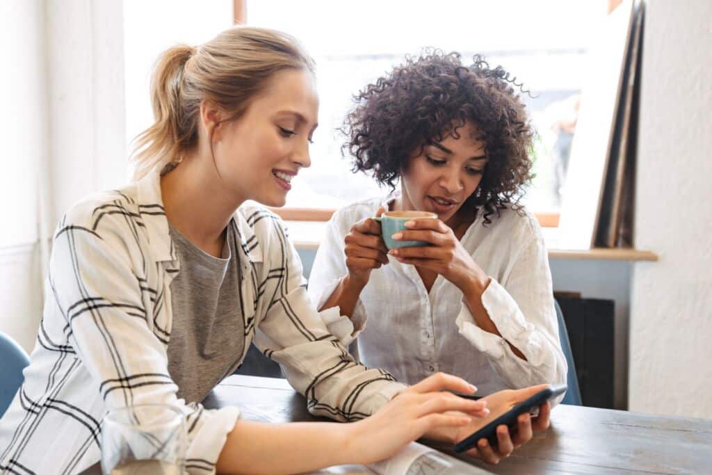 person showing her friend an online product