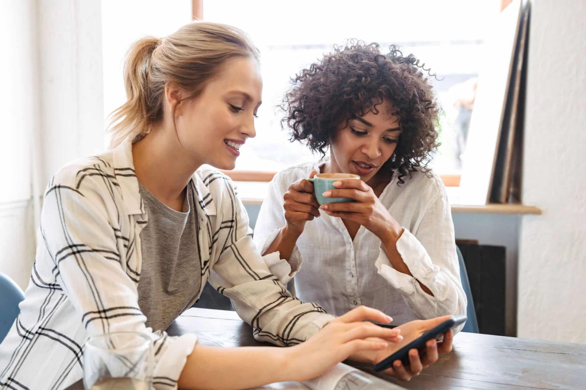 person showing her friend an online product person showing her friend an online product