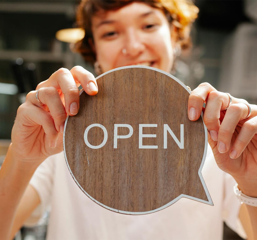 person holding an open sign