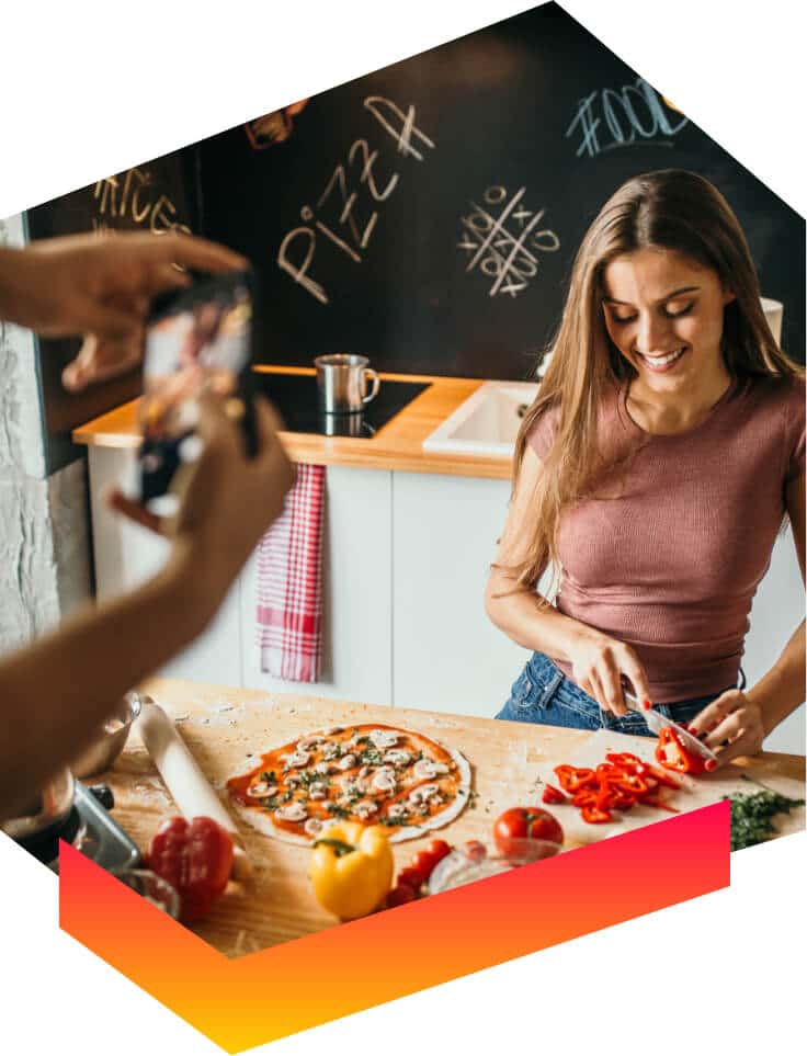 man filming woman creating content marketing how to make pizza
